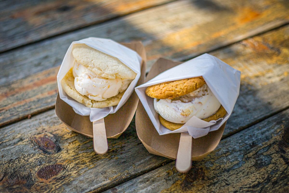 Two ice cream sandwiches in paper wrappers on a rustic outdoor table, used as an editorial illustration for “How limited-time menu items become fan favourites”
