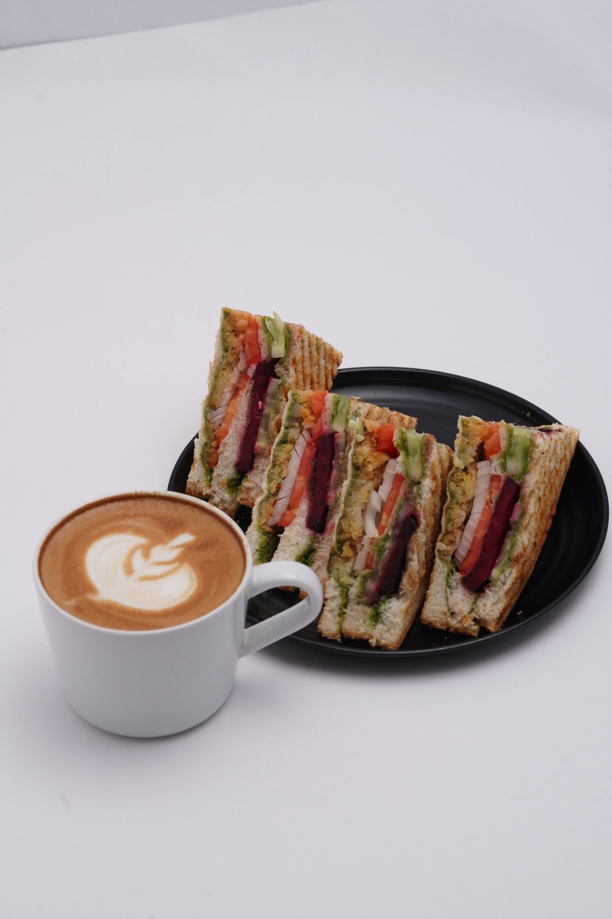 A sandwich platter with a creamy latte